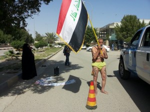 يظهر في الصورة مواطن عراقي يخلع ملابس احتجاجا على عدم تعيين ابنته